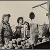 Street scene, women weighing vegetables from a cart