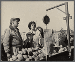 Street scene, women weighing vegetables from a cart