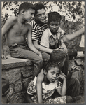 Group of young kids seated outside embracing