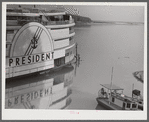 An excursion steamer which goes up the Mississippi River from New Orleans to Saint Louis every summer. It stops along the way at various towns and cities, takes passengers on a four hour "moonlite" ride, has dance orchestra, elaborate ballroom and various kinds of entertainment and amusements. Here it is tied up at Lake Providence, Louisiana before its evening trip