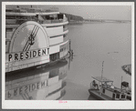 An excursion steamer which goes up the Mississippi River from New Orleans to Saint Louis every summer. It stops along the way at various towns and cities, takes passengers on a four hour "moonlite" ride, has dance orchestra, elaborate ballroom and various kinds of entertainment and amusements. Here it is tied up at Lake Providence, Louisiana before its evening trip