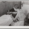 Mrs. Verden Lee sewing on her new sewing machine in her home. Transylvania Project, Louisiana