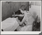 Mrs. Verden Lee sewing on her new sewing machine in her home. Transylvania Project, Louisiana