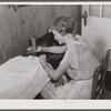 Mrs. Verden Lee sewing on her new sewing machine in her home. Transylvania Project, Louisiana