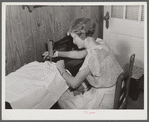 Mrs. Verden Lee sewing on her new sewing machine in her home. Transylvania Project, Louisiana