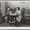 Mr. and Mrs. Verden Lee working on farm family record book in the living room of their home. Transylvania, Project, Louisiana