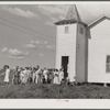 The women's club leaving the church and community building after a home management demonstration by the supervisor and a baby shower they gave for Mrs. Verden Lee, one of their members. Transylvania Project, Louisiana