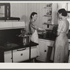 Mrs. Clarence N. Pace canning English peas in her pressure cooker with Miss Louise Martin, the home management supervisor, helping. Transylvania Project, Louisiana