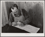 Mr. Verden Lee working on the farm family record book in his home. Transylvania Project, Louisiana