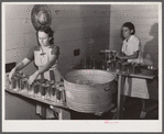 Camp members canning tomatoes in the utility building at Osceola migratory labor camp. Belle Glade, Florida