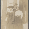 Two women standing with man, full length