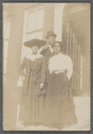 Two women standing with man, full length