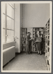 John in library holding book