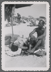 Man sitting next to woman at beach