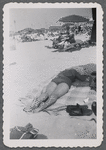 Woman lying on stomach on beach blanket