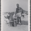 Man in swim trunks next to seated women