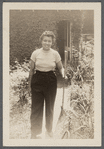 Jean Blackwell Hutson holding rake in garden