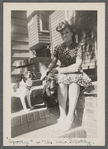 Jean Blackwell Hutson on front stoop with two dogs on steps