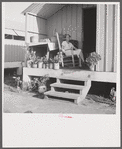 Camp member on porch of her shelter at Osceola migratory labor camp. Belle Glade, Florida