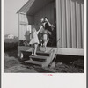 Camp members on porch of their shelter eager for a drink of good water available at the head of each shelter unit. Osceola migratory labor camp, Belle Glade, Florida