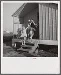 Camp members on porch of their shelter eager for a drink of good water available at the head of each shelter unit. Osceola migratory labor camp, Belle Glade, Florida