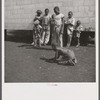 Camp members' children playing marbles outside their shelter units at Okeechobee migratory labor camp. Belle Glade, Florida