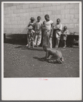 Camp members' children playing marbles outside their shelter units at Okeechobee migratory labor camp. Belle Glade, Florida