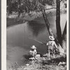 Cajun children fishing in bayou near the school by Terrebonne Project. Schriever, Louisiana