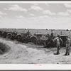 Tractors in the sugarcane fields, with the farm supervisor discussing the problem of cultivation after excessive rains with the foreman, who was chosen from among their own group by the members of the cooperative. Terrebonne Project, Schriever, Louisiana