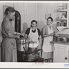 Mrs. Ruth Lina, home management supervisor, helping some of the project women can milk. Terrebonne Project, Schriever, Louisiana