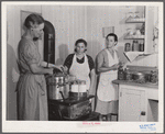 Mrs. Ruth Lina, home management supervisor, helping some of the project women can milk. Terrebonne Project, Schriever, Louisiana