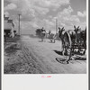 After the noon hour in the plantation yard, the mules, tractors and cultivators are taken out to finish the day's work. King and Anderson Plantation, near Clarksdale. Mississippi Delta, Mississippi.