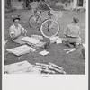 Boys in Natchitoches, Louisiana, folding papers before delivering them in the afternoon