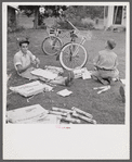 Boys in Natchitoches, Louisiana, folding papers before delivering them in the afternoon