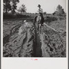 Melrose, Natchitoches Parish, Louisiana. [Multiracial person] riding to crossroads store to get supplies after heavy rains