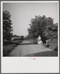 Melrose, Natchitoches Parish, Louisiana. [Multiracial person] returning home after buying supplies at country store