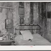 Melrose, Natchitoches Parish, Louisiana. Bedroom with religious pictures, etc. on mud walls of old hut built and still occupied by French [multiracial people], near John Henry cotton plantation. Belongs to Rocque family (see general caption)