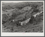 General landscape near Hyden, Kentucky showing mountain cabins, sheds and cornfields.
