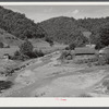 General landscape near Hyden, Kentucky showing mountain cabins, sheds and cornfields.