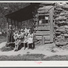 Mountain family on porch of their home made of hand hewn logs up South Fork of Kentucky River, Breathitt County, Kentucky.