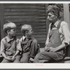 Mountaineer with his two grandsons whom he raised in his home with the help of the neighbors. He had been crippled with arthritis most of his life. On the steps of a schoolhouse on South Fork of Kentucky River. Breathitt County, Kentucky.