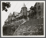 View of houses on enbankment above street. Hempstead, Hempstead