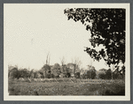 View of house behind fence and trees. North of North Hempstead Turnpike. Greenvale, Oyster Bay