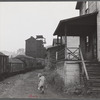 Coal miner's child taking home kerosene for lamps. Company houses, coal tipple in background. Pursglove, Scotts Run, West Virginia.