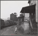 Coal miner's child taking home kerosene for lamps. Company houses, coal tipple in background. Pursglove, Scotts Run, West Virginia.