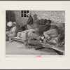 Farmers sleeping in [Black] camp room in warehouse. They often must remain overnight or several days before their tobacco is auctioned. Several of them are using an old tobacco basket for a pillow. Durham, North Carolina.