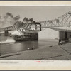 Riverboat carrying cargo leaving dock along waterfront. Louisville, Kentucky. Ohio River.