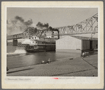 Riverboat carrying cargo leaving dock along waterfront. Louisville, Kentucky. Ohio River.