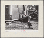 Reading the newspaper outside his trailer home. Sarasota trailer park, Sarasota, Florida.