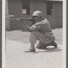 Man in uniform kneeling with rifle